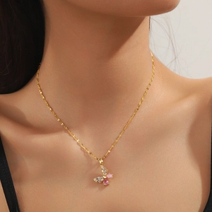 Close-up of golden bow-knot butterfly necklace with pink and white cubic zirconia crystals