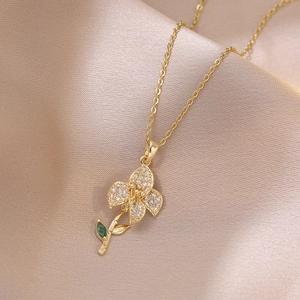Golden flower pendant necklace with white zircon petals and emerald green gemstone leaf