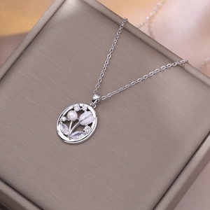 Elegant silver tulip necklace with pearl and rhinestones on a brown display box