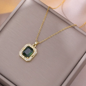 Vintage gold chain necklace featuring an emerald green zircon pendant with diamond halo
