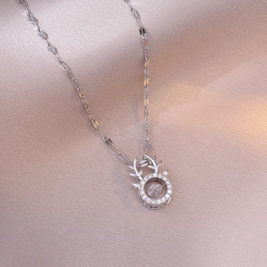 Elegant deer antler dancing stone necklace with sparkling zircon pendant on pink fabric