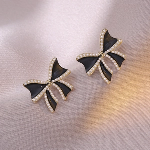 Vintage zwarte strik oorbellen met parels en goudkleurige rand voor een retro look