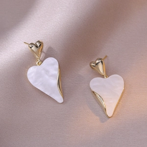 Elegant 925 silver needle heart drop earrings with shell texture and gold border on pink silk