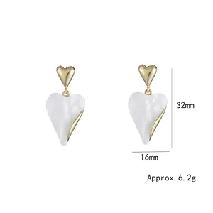 Minimalist heart-shaped two-tone drop earrings with gold rim and white marble texture