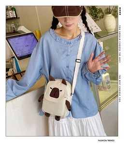 Detail of cute white canvas Capybara crossbody bag with 3D ears and adjustable strap