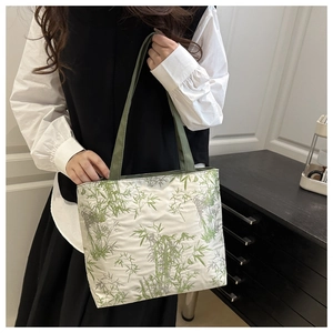 Détail d'un sac cabas blanc avec imprimé bambou vert et bandoulières vert foncé chic