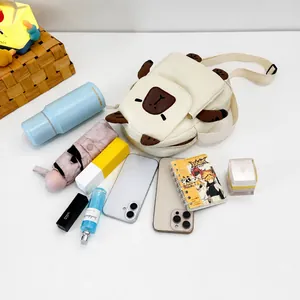 Spacious interior of white canvas crossbody bag showing phone, umbrella and notebook