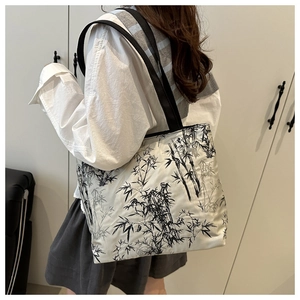 Detail of large tote bag featuring ink bamboo print on gray fabric and black straps