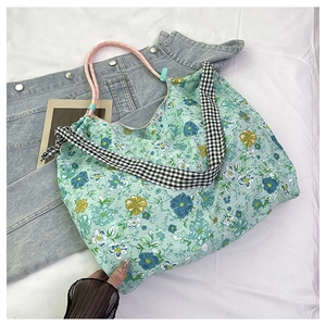 Detailed view of floral canvas tote with checkered strap and colorful cord handle