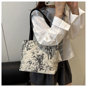 Détail d'un sac cabas en toile avec imprimé bambou à l'encre et bandoulières noires