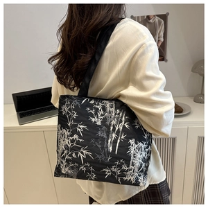 Détail du sac cabas en toile avec motif de bambou blanc sur fond noir élégant