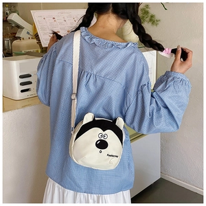 Détail du petit sac à bandoulière husky porté sur une chemise à carreaux bleue