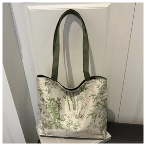 Detailed macro view of the silky satin tote bag featuring elegant green bamboo prints