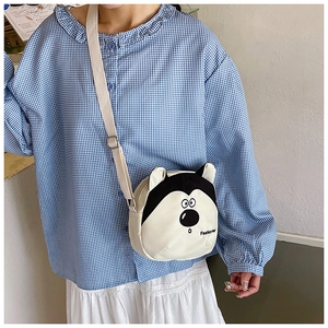 Détail du sac bandoulière en toile husky avec sangle réglable et broderie tendance