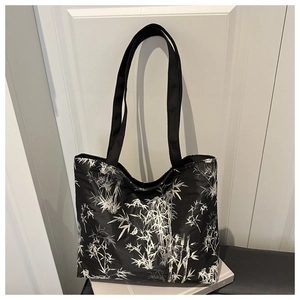 Detail of large tote bag with white bamboo print on black nylon fabric for daily use