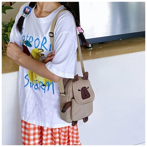 Detail showing the adjustable shoulder strap and Capybara cartoon bag on a person
