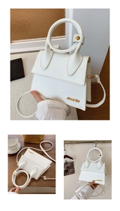 Detail of white leather handbag with oversized round handle and gold metal hardware