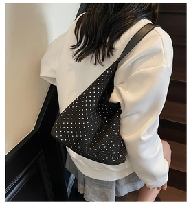 Rear view of a model wearing a black rhinestone hobo bag with sparkling silver crystals