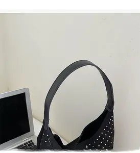Detail of comfortable handle and sparkling studded denim surface of this underarm bag