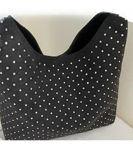 Close-up of black suede shoulder bag with shimmering silver rhinestones and soft texture