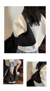 Detail view of black suede shoulder bag with small studs in a minimalist crescent shape