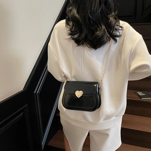 Classic black patent leather saddle bag with golden heart buckle and fine chain strap