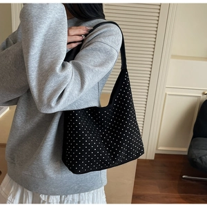 Detail shot of a black hobo bag featuring silver rhinestone accents and shoulder strap