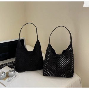 Detail view of black hobo bags featuring one sleek suede finish and one silver rhinestone pattern