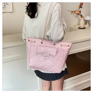 Sac à dos matelassé rose avec bretelles en chaîne et poche avant porté par le mannequin