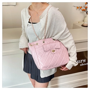 Détail du sac bandoulière en cuir rose matelassé avec bandoulière chaîne et fermoir