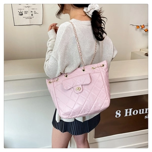 Gros plan du sac bandoulière rose matelassé avec chaîne dorée et détails métalliques