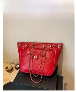 Détail du sac fourre-tout en cuir matelassé rouge avec fermoir doré et bandoulière