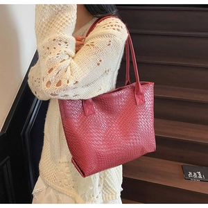 Détail de la texture tressée et du fini bordeaux profond sur ce sac cabas vintage