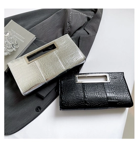 Detail of silver and black crocodile-embossed clutch bags with sleek metal cutout handles
