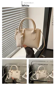 Detail der cremeweißen Eimertasche aus Kieselleder mit Griff und Metallriemen