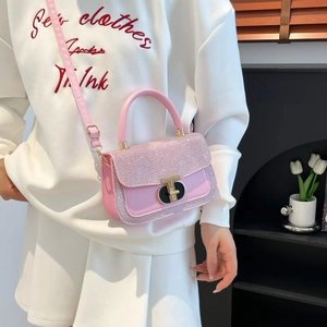 Pink sequin crossbody bag with gold handle and T-lock shown on a model side-carry