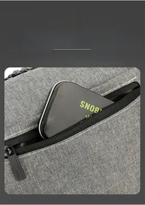 Detailopname van de grijze schoudertas met een veilige ritszak aan de achterkant voor opslag