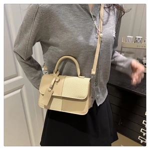 Détail d'un sac à main patchwork beige avec motifs tissés et bandoulière en cuir