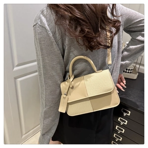 Détail du sac à main beige en patchwork avec texture tissée et bandoulière sur modèle