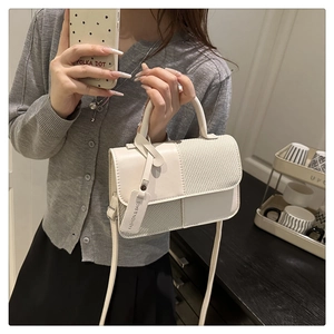 Détail du mini sac à bandoulière en cuir blanc crème et tissu tissé avec poignée