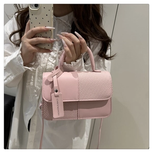 Détail d'un sac à main patchwork rose avec cuir lisse et texture tissée en selfie miroir