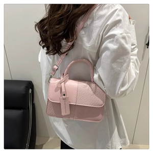 Détail du sac à main en cuir PU rose avec texture tissée, bandoulière et pendentif