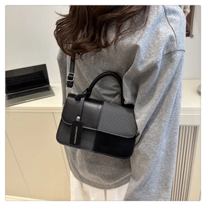 Détail du sac à main minimaliste en patchwork noir et gris avec étiquette décorative