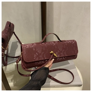 Dunkelrote Baguette-Tasche in Schlangenoptik mit Metallverschluss und langem Schultergurt