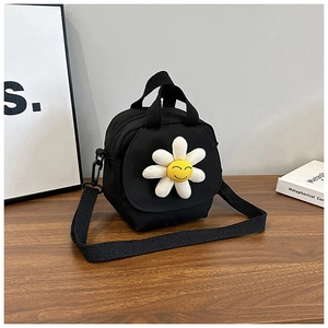 Close-up of black canvas daisy bag with 3D floral detail on a wooden desktop