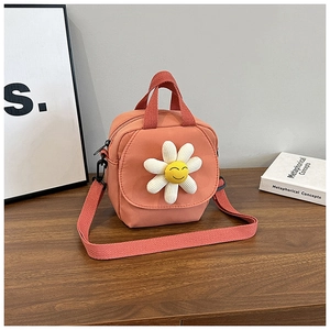Detail of orange canvas crossbody bag featuring a 3D daisy flower with a smiley face center