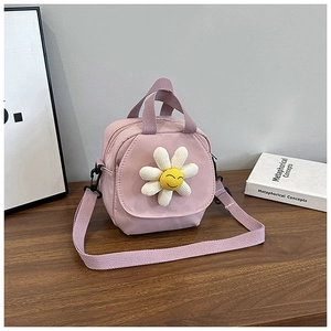 Detail of purple canvas crossbody bag with white daisy charm and dual zipper closure