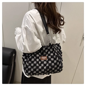 Detail of checkered tote bag with textured tufting and brown leather fashion label