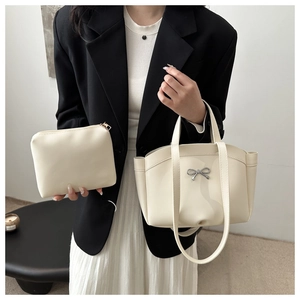 Détails du sac seau blanc avec nœud métallique élégant et pochette intérieure assortie