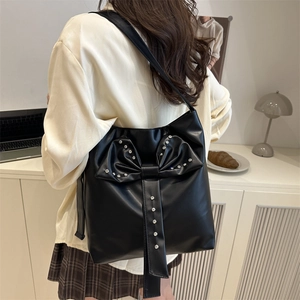 Black tote bag with oversized studded bow and rhinestone accents in sleek leather